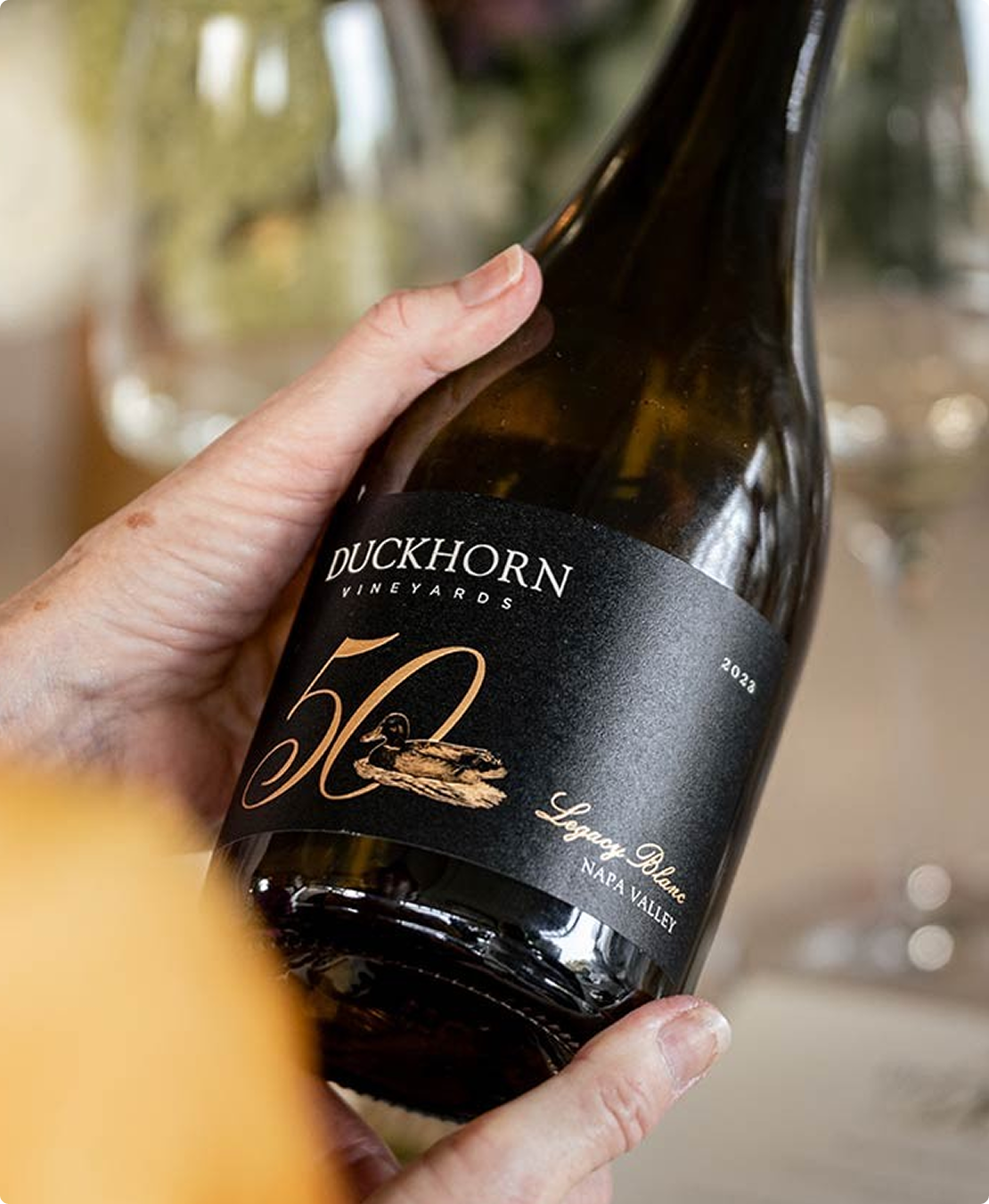 Hand holding a Duckhorn Vineyards Sauvignon Blanc wine bottle